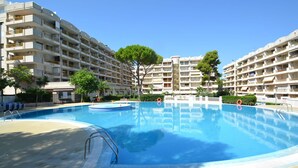 A swimming pool surrounded by multi-story residential buildings with balconies. - Lovely apartment for 4 people with pool, WIFI, A/C, TV and terrace (Salou)