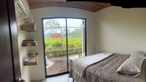 A bedroom with a bed, a window, and a view of a garden. - Don Cidales House (Pocosol)