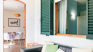 Ein modernes Wohnzimmer mit einer Ledersofa, grünen Rollläden und einem Essbereich mit Tisch und Stühlen.