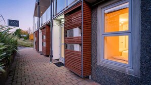 A modern building with large windows and a brick pathway. - The Nugget-Free Parking-Direct Lake Access (Queenstown)