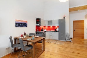 Eine moderne Küche mit Essbereich, Holzboden und einem Gemälde an der Wand.