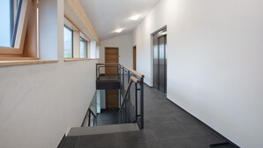 A modern interior with a staircase, a wooden ceiling, and a door leading to another room. - Apartment 'Hedi' with Mountain View, Balcony and Wi-Fi (Feldberg (Schwarzwald))