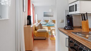 Eine moderne Küche mit Mikrowelle, Herd und Kaffeemaschine.