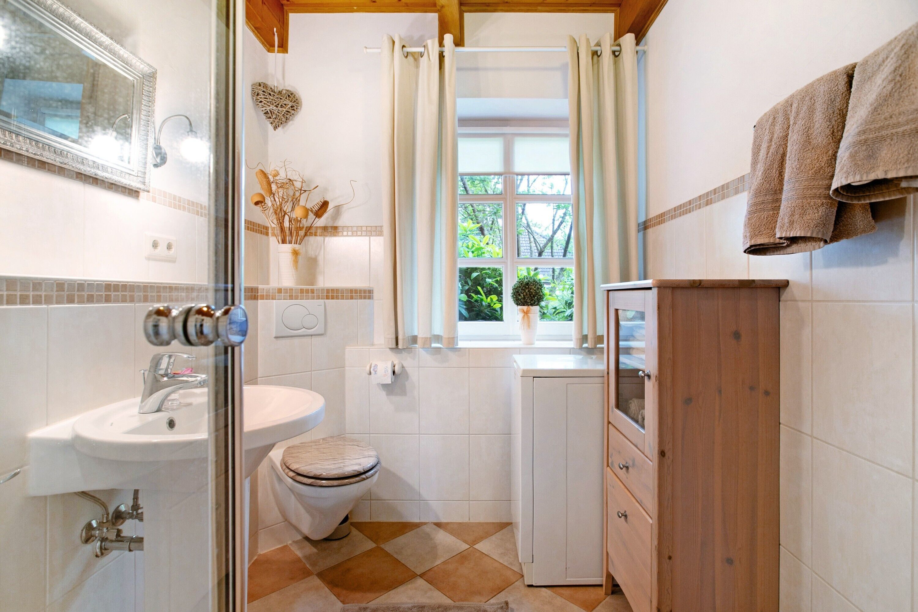 Et badeværelse med toilet, vask og brusebad.