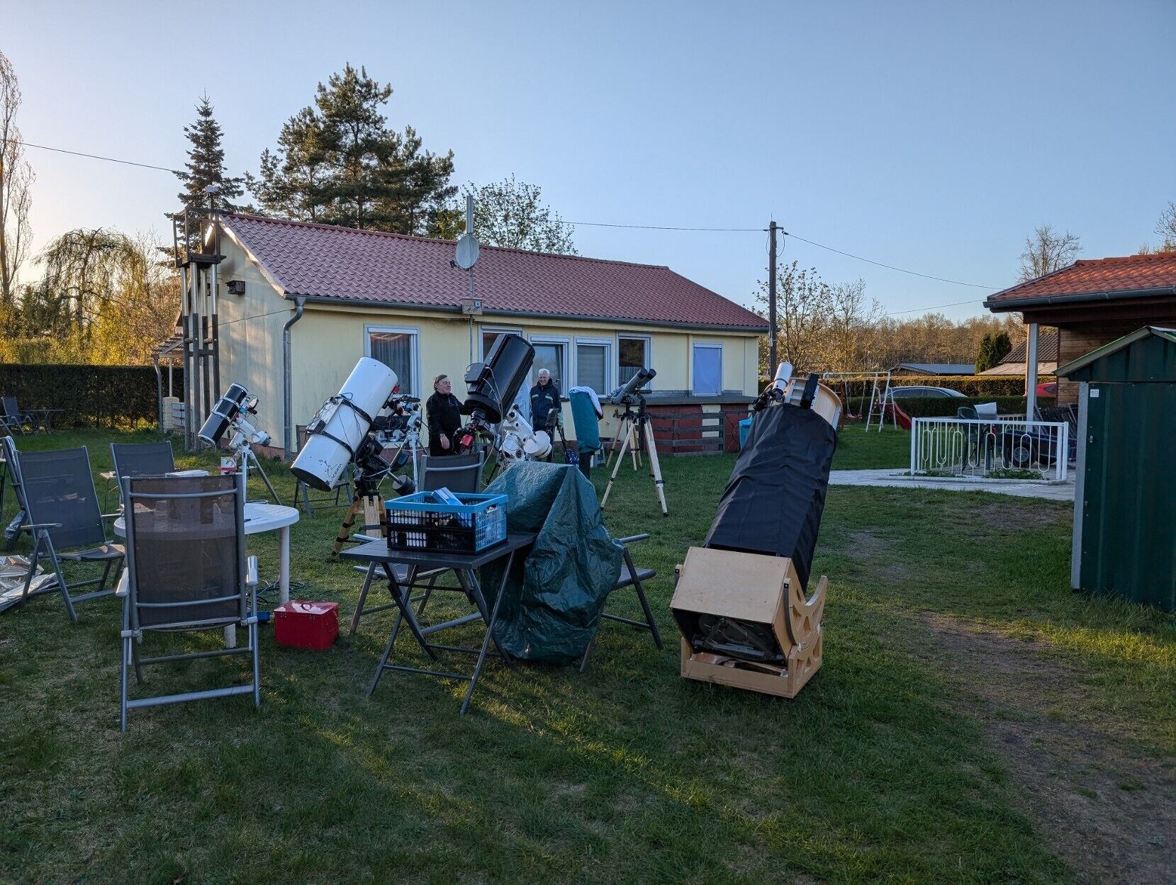 Asuinalue, jossa on talo, kaukoputki ja vihreä varasto.