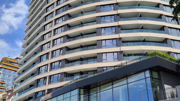 Et hotel med flere etager, en buet facade, store vinduer og en glasindgang.