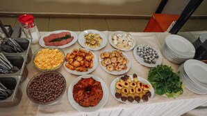 Una mesa de buffet con diversos alimentos y utensilios.