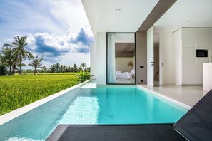 Een moderne hotelkamer met een privézwembad, uitzicht op een weelderig groen veld en een minimalistisch interieur.