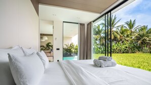 A modern hotel room with a large bed, a view of a swimming pool, and lush greenery outside. - GREEN FLOW Villas III Ubud (Ubud)