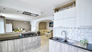 Cozinha moderna com ilha central, armários embutidos e painel de azulejos hexagonais.