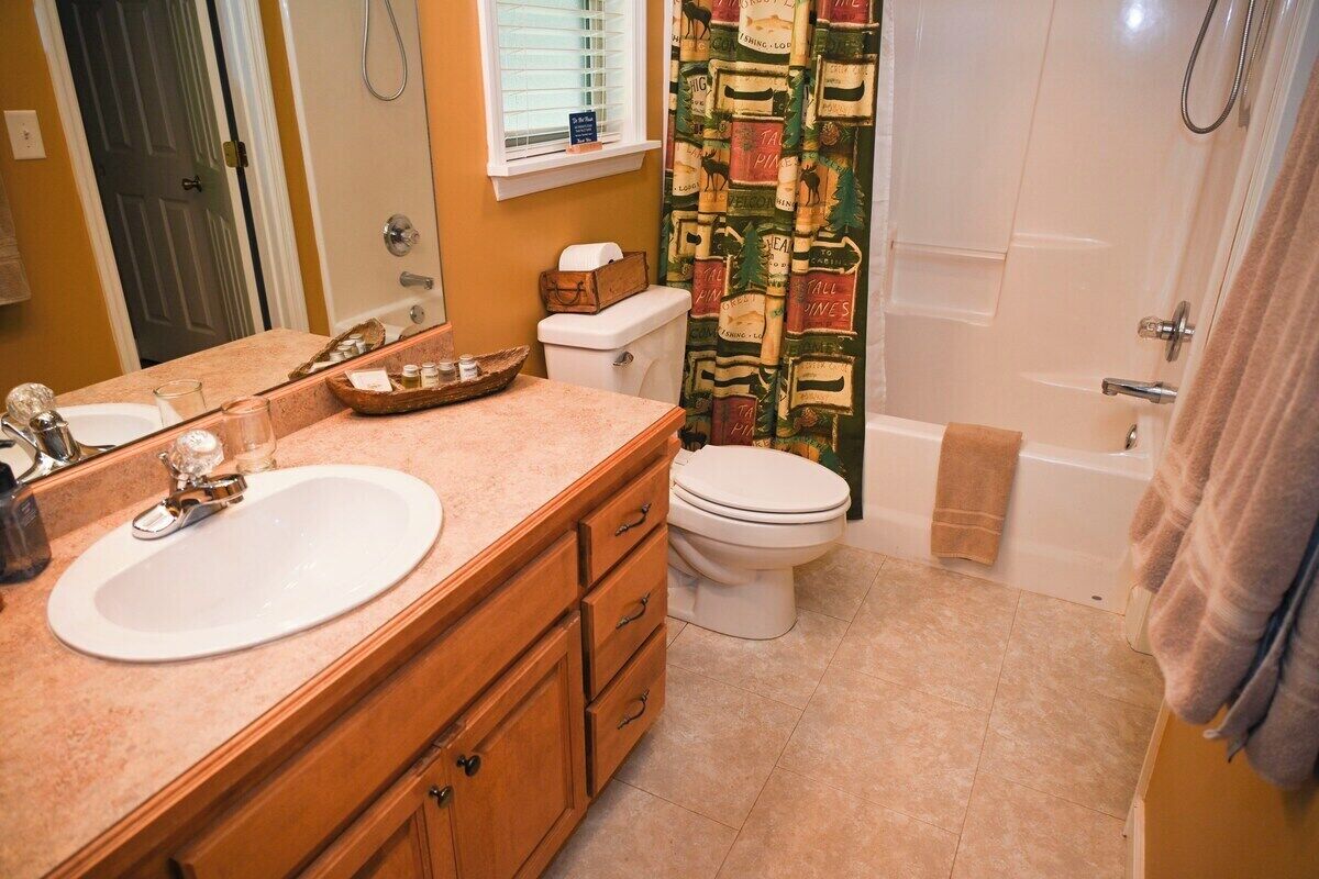 A bathroom with a sink, toilet, and bathtub.