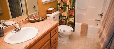 A bathroom with a sink, toilet, and bathtub.