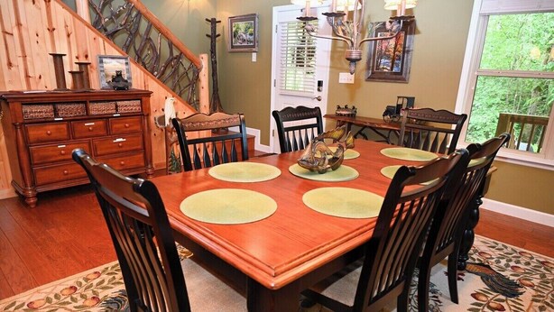 Un espace repas comprenant une table en bois, des chaises et un élément décoratif central.