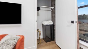 Ein modernes Badezimmer mit Dusche, Handtuchhalter und einem kleinen Tisch mit einem Handtuch.