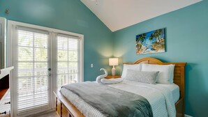 Une chambre à coucher avec un lit, une table de chevet, une lampe et un tableau au mur.