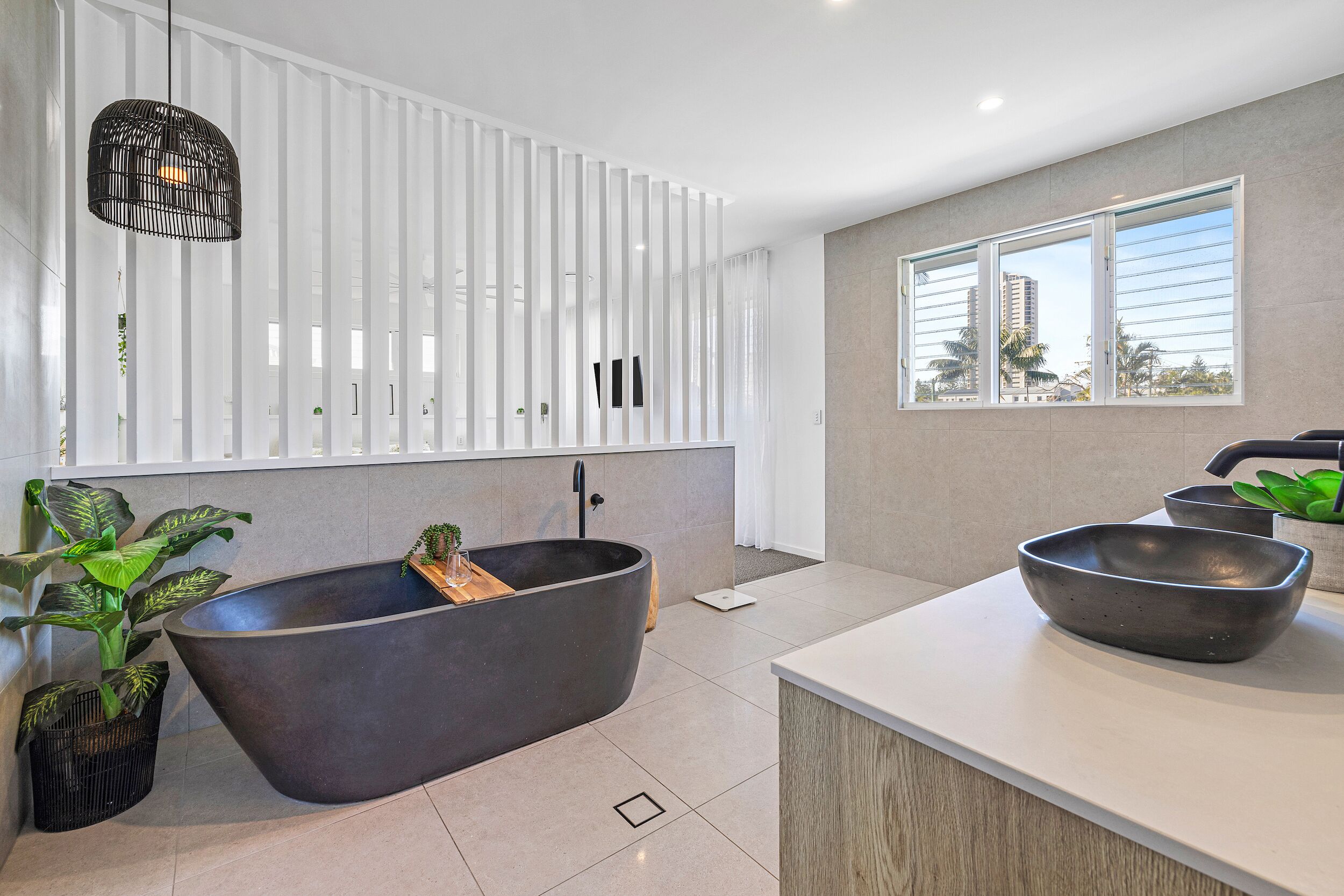 A modern bathroom with a freestanding bathtub, a large window, and a minimalist design.
