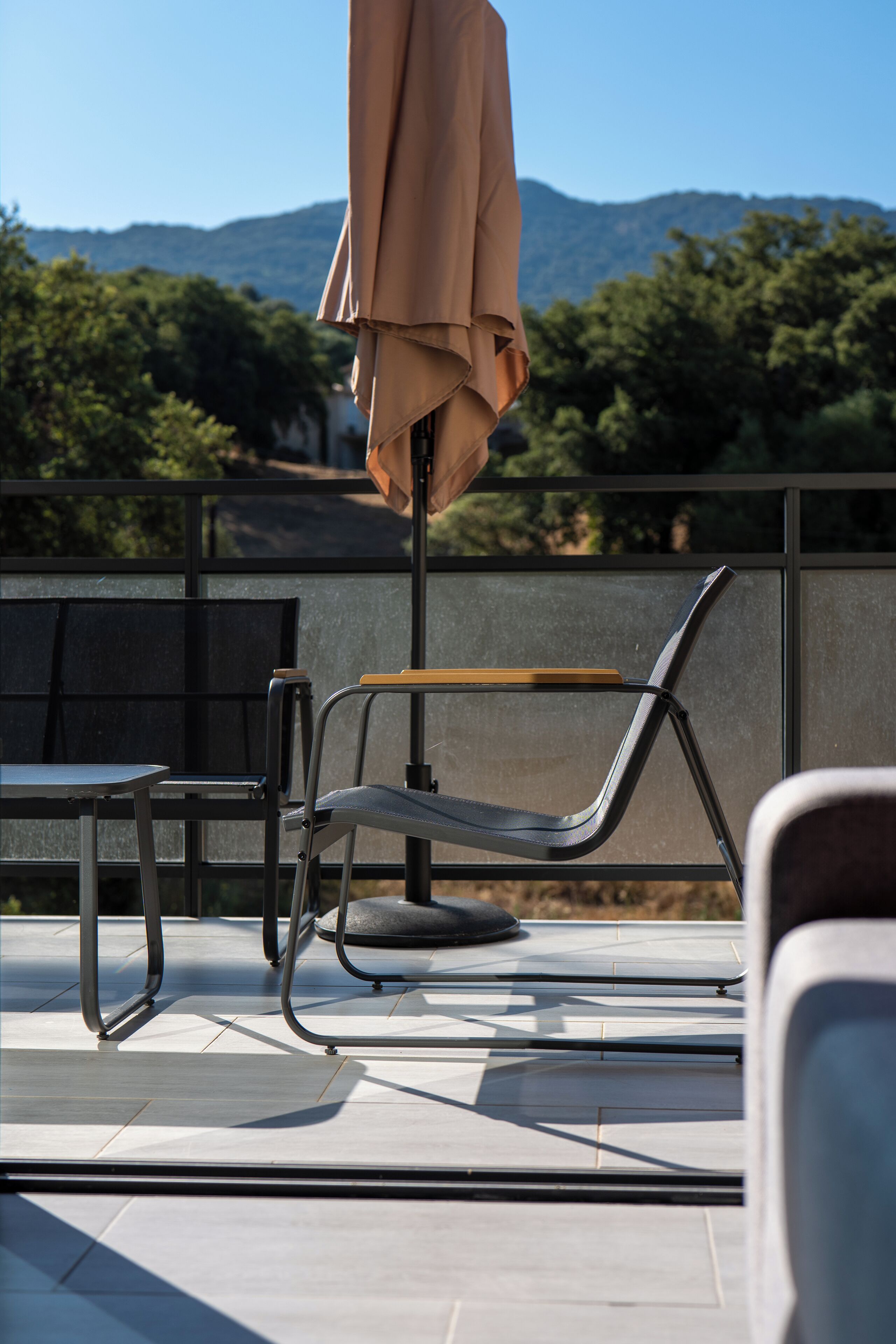 Une terrasse avec une table, des chaises et un parasol.