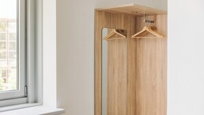 Un armario de madera con dos perchas de madera.