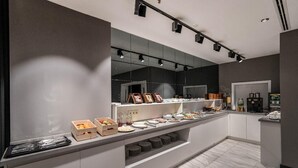 Una cocina moderna con encimera de mármol, electrodomésticos integrados y un espejo grande sobre la encimera.