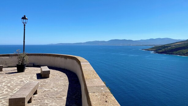 A coastal promenade with a curved stone wall, a street lamp, and a potted plant. - Vacation House with panoramic terrace (Castelsardo)