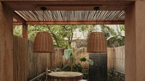 A wooden table with a bowl of fruit, a round wooden tub, and two wicker lamps. - qingyuansanhedaoli (Qingyuan)