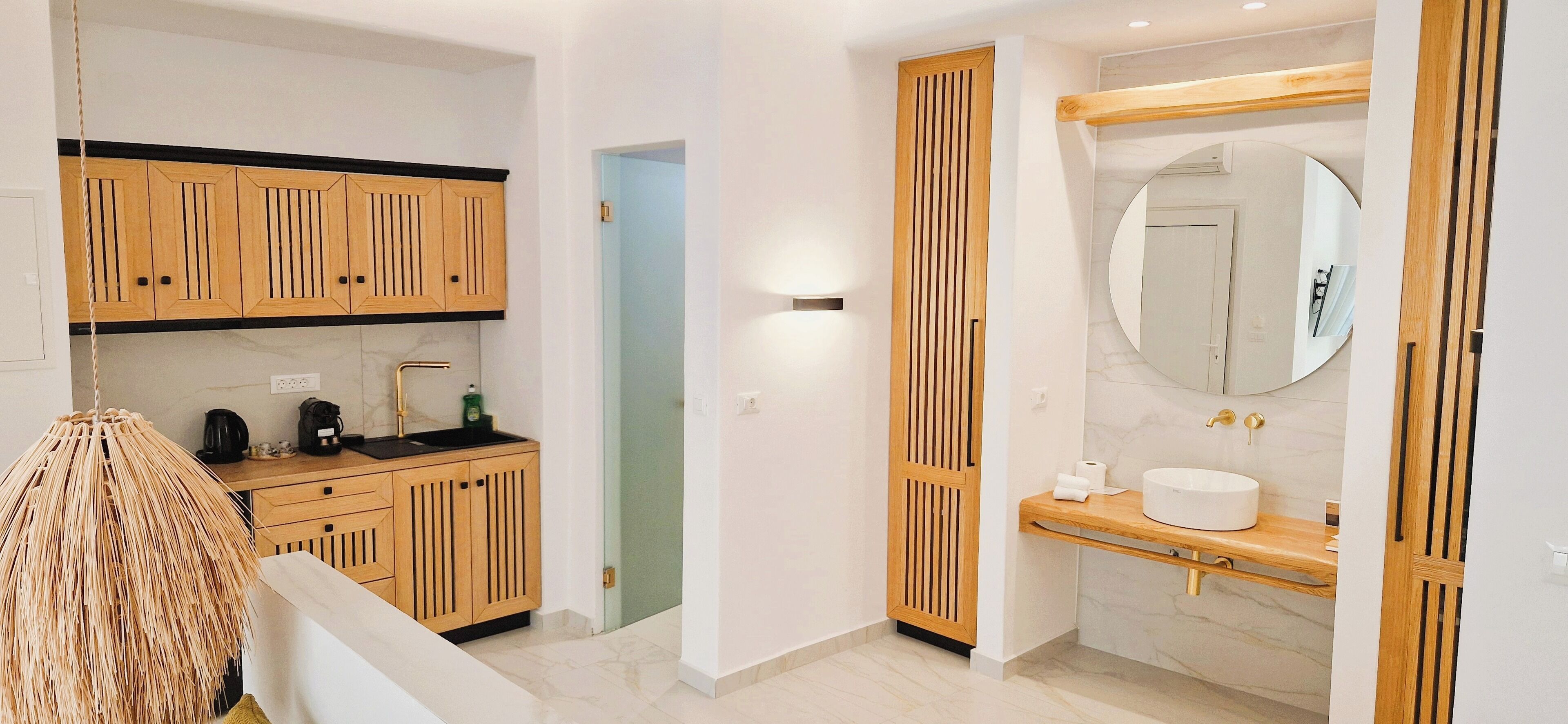 A modern bathroom with a wooden vanity, a round mirror, and a built-in toilet.