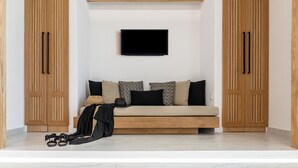 A modern living room with a sofa, a flat-screen TV, and wooden cabinets. - V Luxury Apartments Naxos (Naxos)