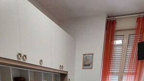 Une chambre avec deux lits, un bureau et une fenêtre avec des rideaux.