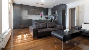 Un appartement moderne comprenant un espace de vie, une cuisine et un coin repas.