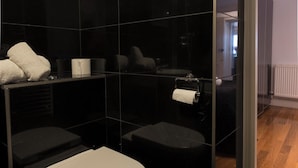 Une salle de bain moderne avec des toilettes, un lavabo et un miroir.