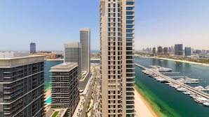 A high-rise building with a marina and a beach in the background. - Marina Vista Emaar Beachfront Apartments (Dubai)