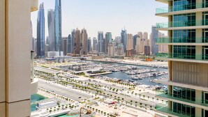A high-rise building with a marina and cityscape in the background. - Marina Vista Emaar Beachfront Apartments (Dubai)
