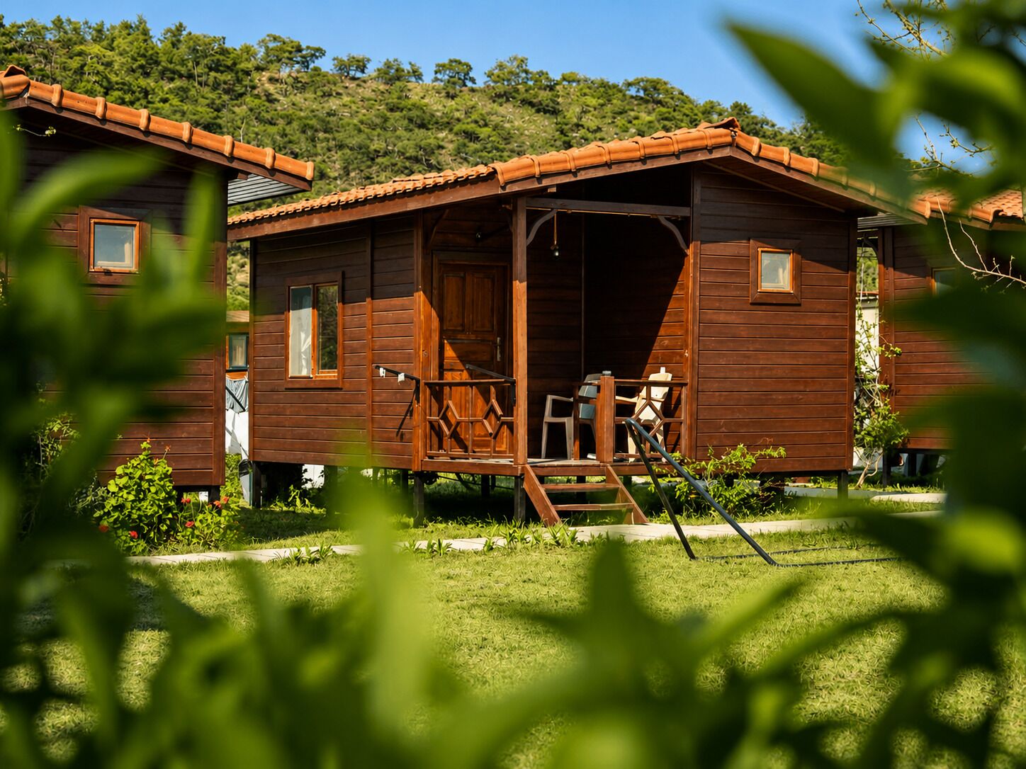 Uma cabana de madeira com varanda, porta e janela.