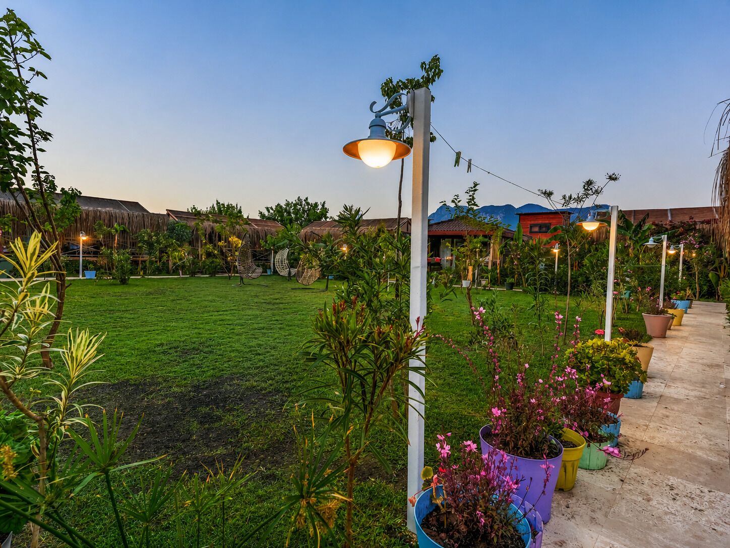 A well-maintained garden with a lawn, potted plants, and outdoor seating.