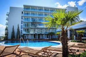 Piscine extérieure, parasols de plage, chaises longues