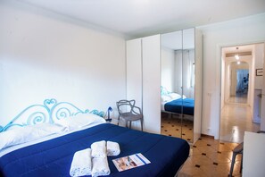 A hotel room with a large bed, a chair, a desk, and a mirror. - Matteo's Flat (Sanremo)