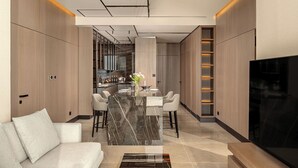 A modern kitchen with a marble island, bar area, and seating. - Amathus Residences (Limassol)