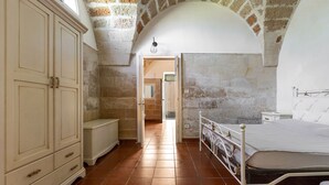 A bedroom with a bed, a wardrobe, and a bathroom visible through an archway. - 3936 Corte dei Falconi by Barbarhouse (Lecce)