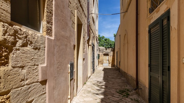 A narrow cobblestone alleyway between buildings with stone walls and wooden shutters. - 3936 Corte dei Falconi by Barbarhouse (Lecce)