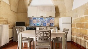 A compact kitchen with a tiled backsplash, a built-in oven, and a refrigerator. - 3936 Corte dei Falconi by Barbarhouse (Lecce)