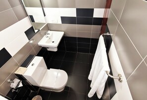 A bathroom with a toilet, sink, and towel rack. - Cloud Nine Retreat (Nuwara Eliya)
