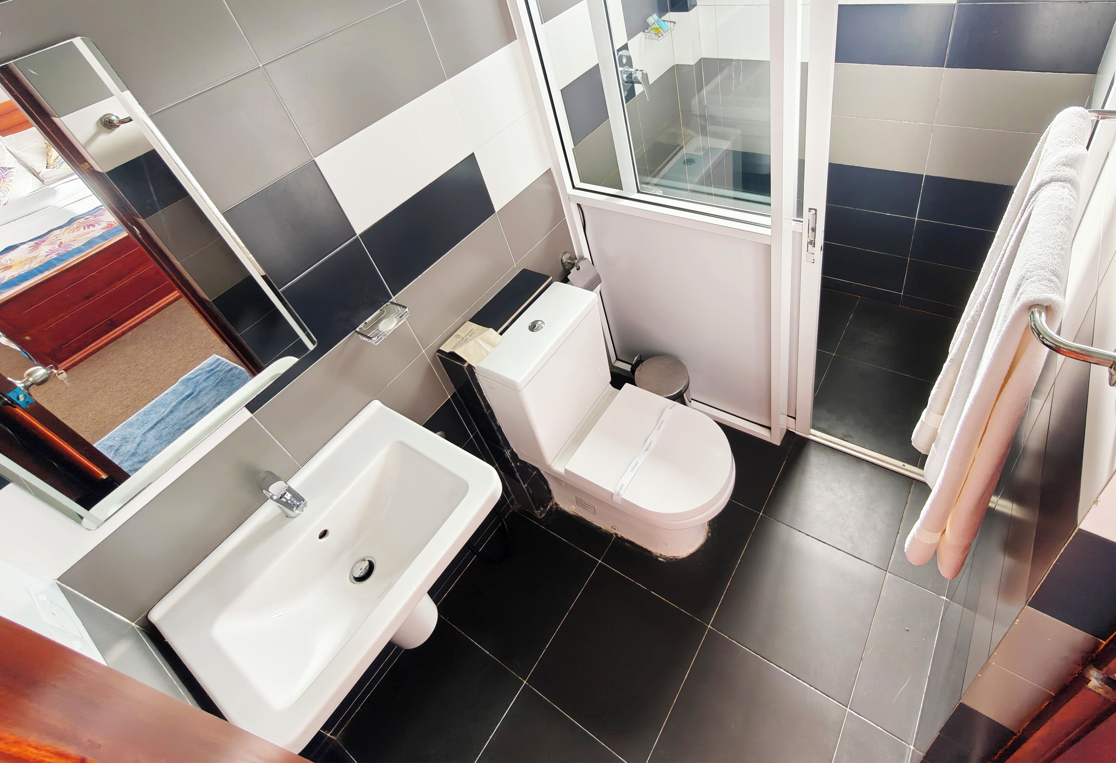 Un baño con inodoro, lavamanos y zona de ducha.