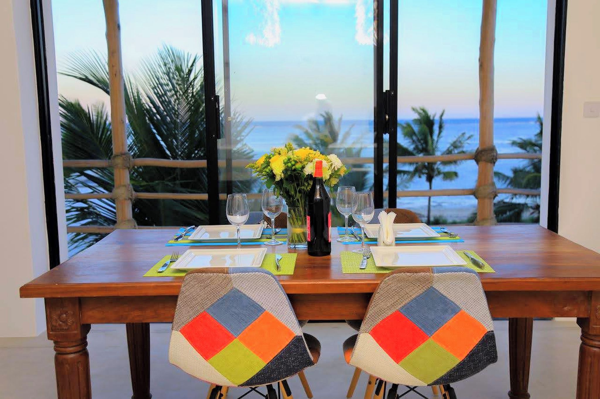 A dining table set for two with a view of the ocean.