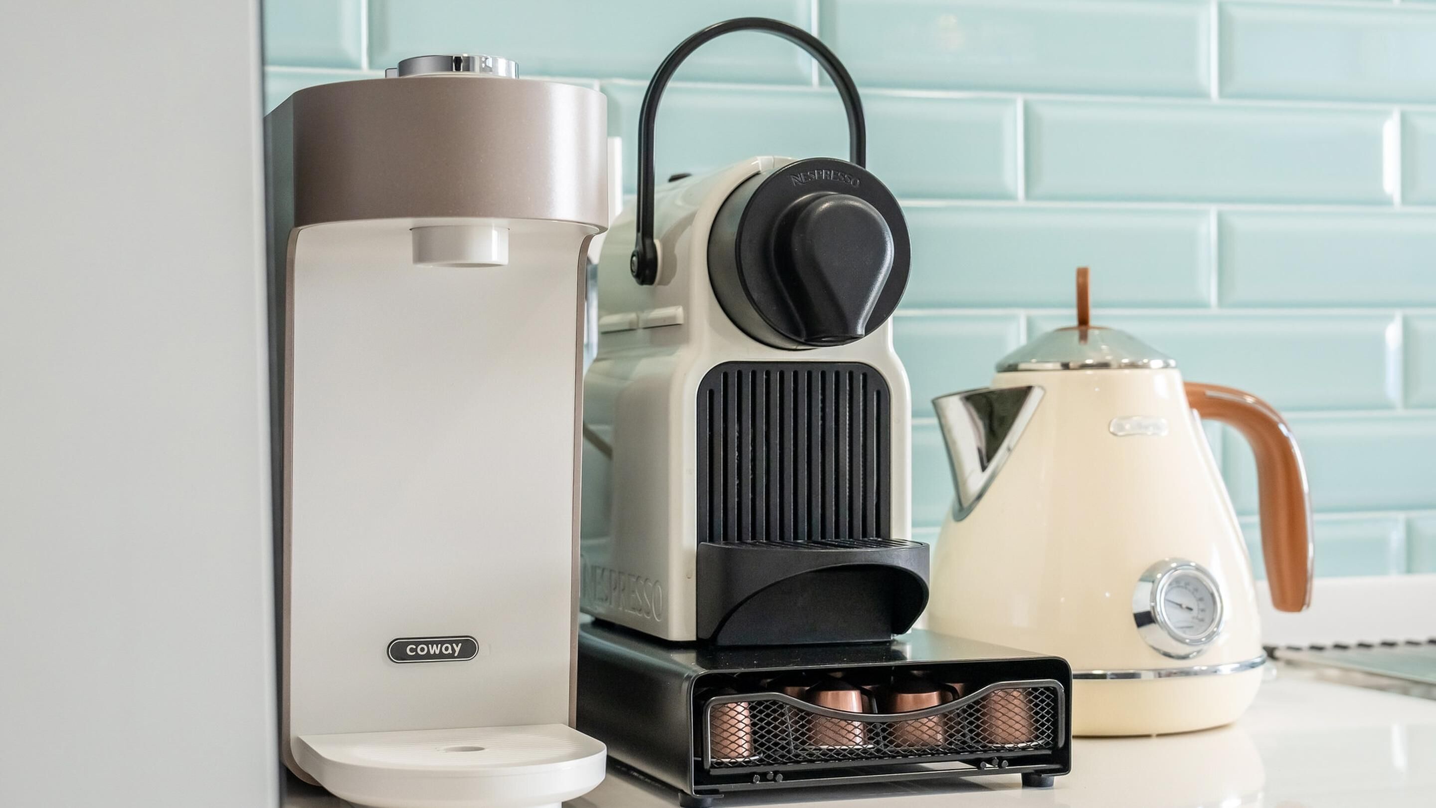 Een keuken met een koffiezetapparaat, een waterkoker en een koffiemachine.