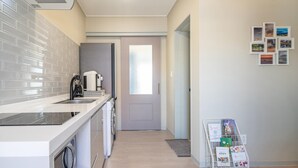 Una cocina moderna con horno empotrado, cafetera y lavadora.