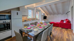 Une cuisine moderne avec un coin repas, un canapé rouge et un téléviseur.
