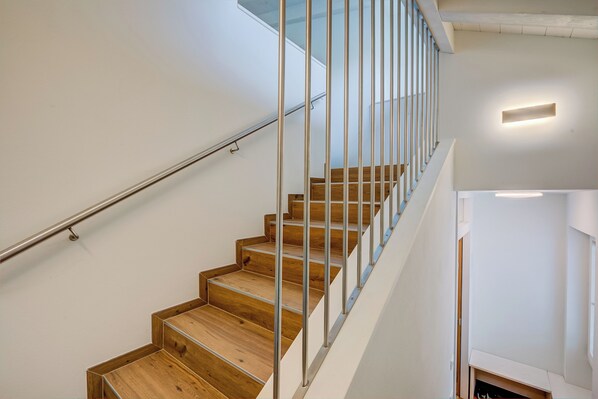 A modern staircase with wooden steps and metal railings, leading to an upper floor. - Cimetta (Livigno)