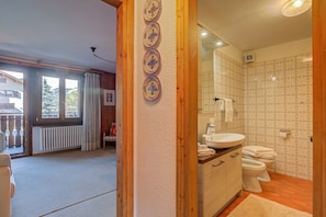 Une salle de bain avec un lavabo, des toilettes et des carreaux décorés.