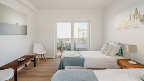 Ein Hotelzimmer mit zwei Betten, einem Schreibtisch, einem Stuhl, einer Lampe und einem Bild an der Wand.