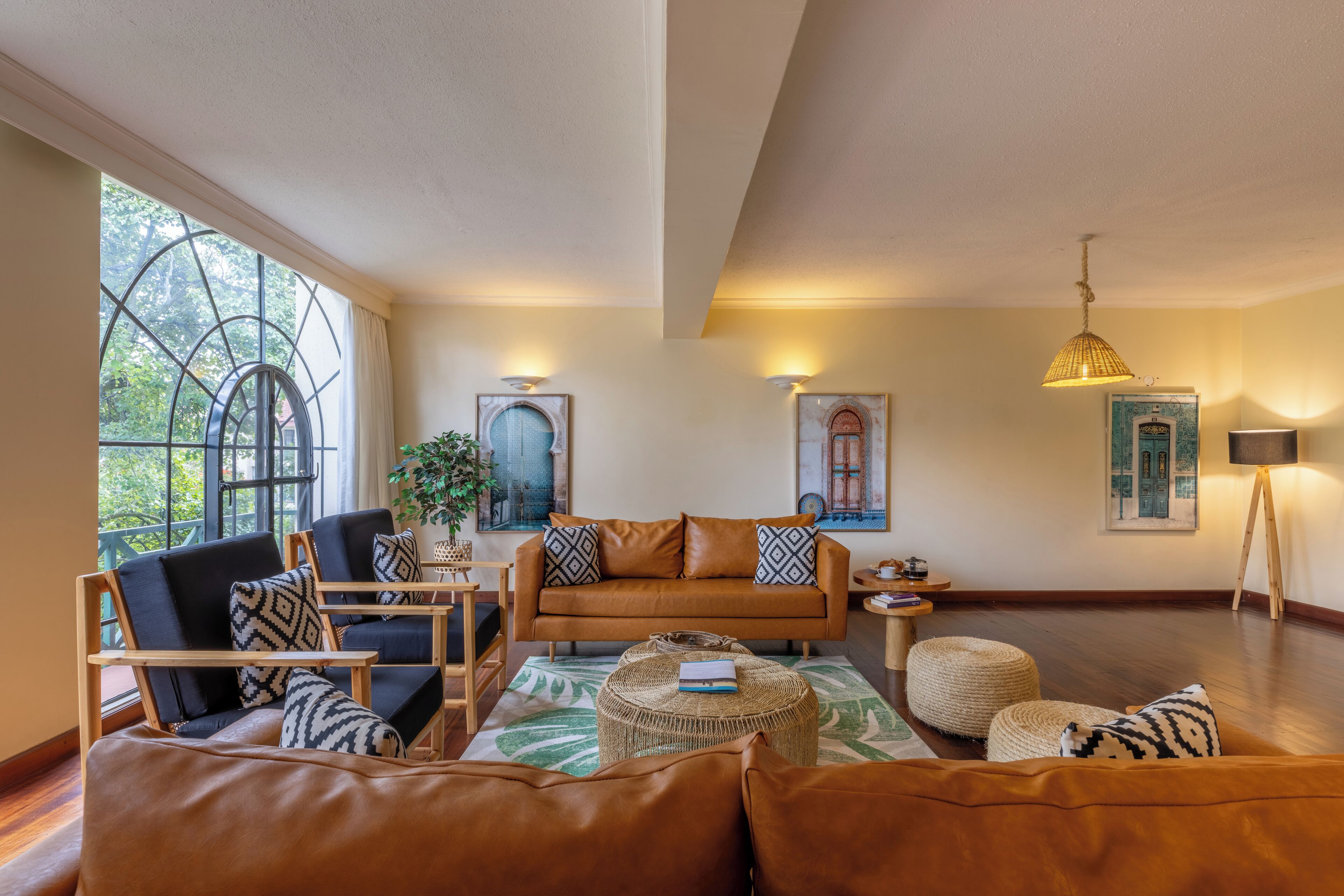 Un salon comprenant un canapé, des fauteuils, une table basse et des œuvres d’art accrochées aux murs.